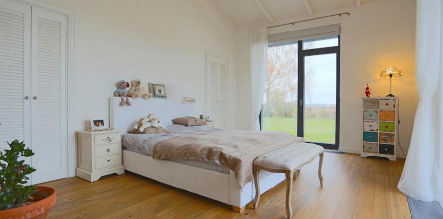 Дом со скромным фронтальным видом, расположенный на тихой улице частных домов в окрестности леса. 