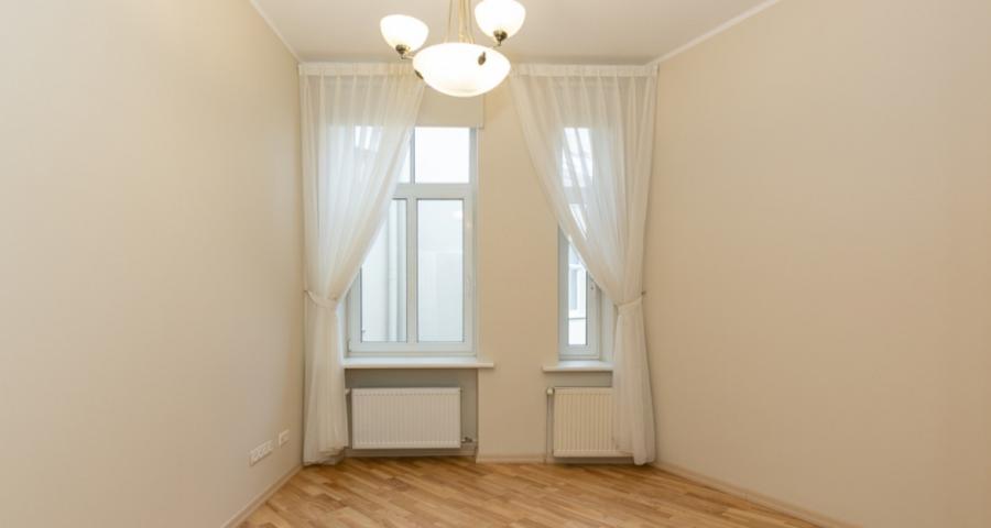 Spacious living room with large windows facing the Daugava River. 