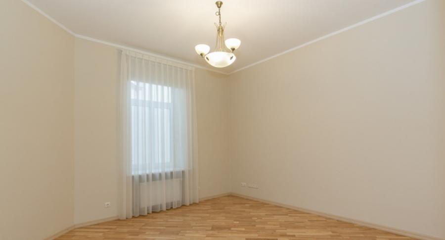 Spacious living room with large windows facing the Daugava River. 