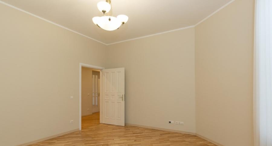 Spacious living room with large windows facing the Daugava River. 